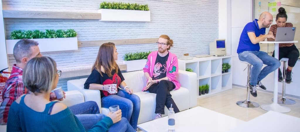 Redsauce team discussing automated tests in the Barcelona offices, looking at a computer