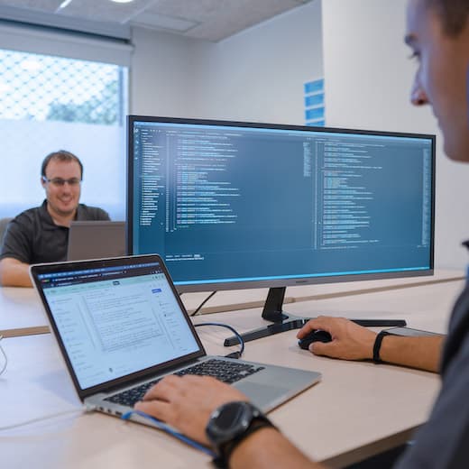 Employees of Redsauce looking at functional test automation on a laptop