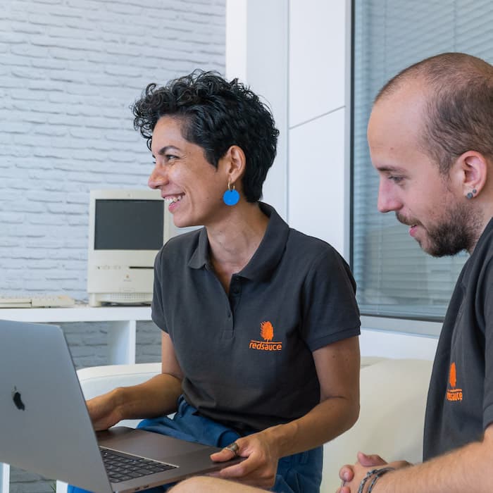 Redsauce employees doing software quality tests on a laptop